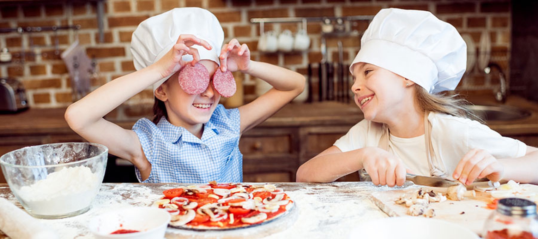 kinderen pizza maken koksmuts salami champignons meel