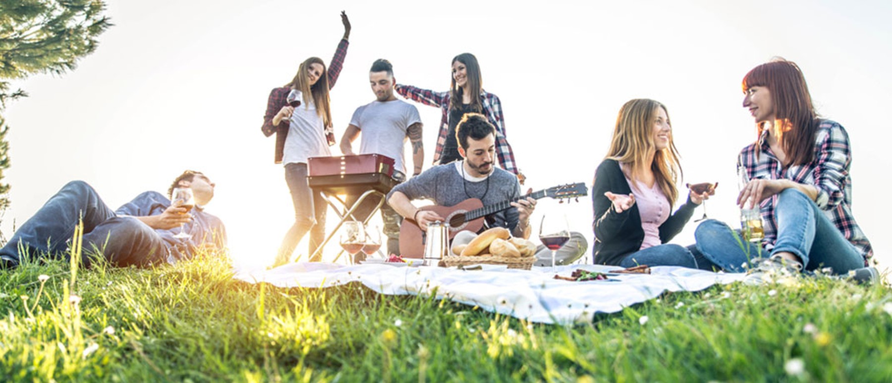 Een groepje vrienden die buiten muziek en plezier maakt tijdens een picknick