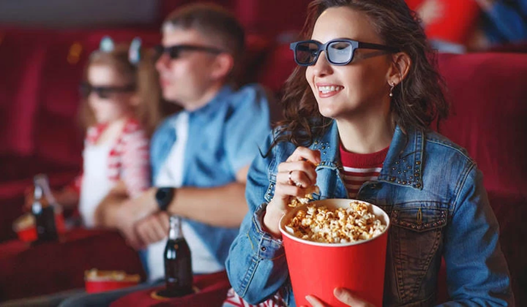 Vrouw eet popcorn in bioscoop