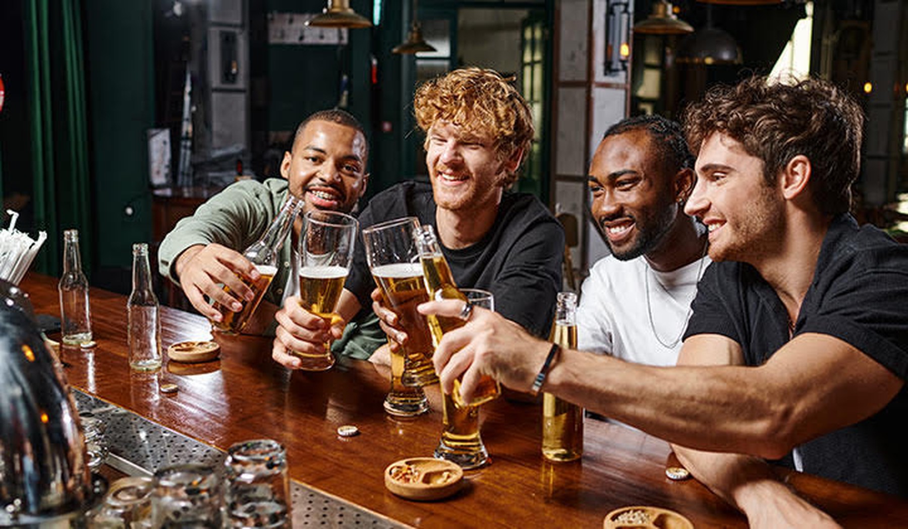 Mannen zitten aan de bar met bier