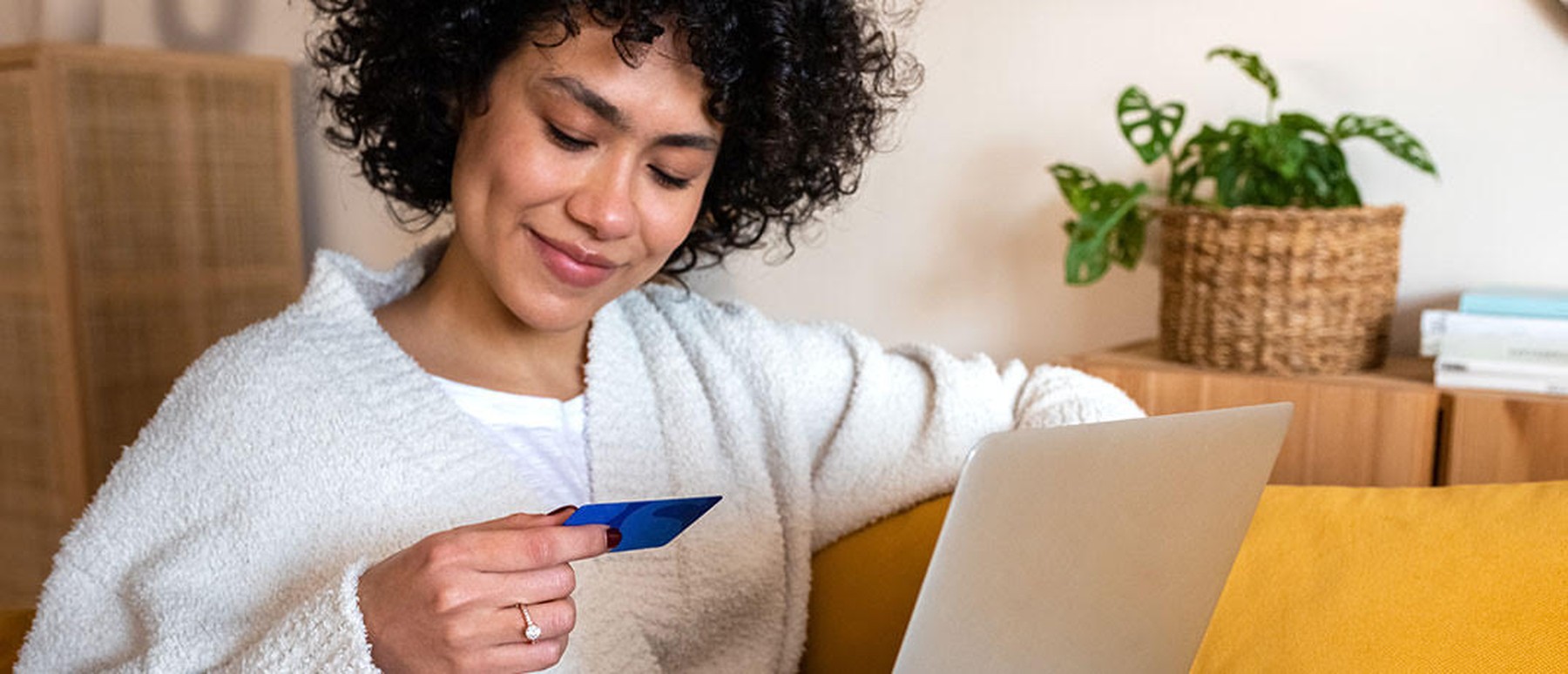 Vrouw met creditcard en laptop op schoot