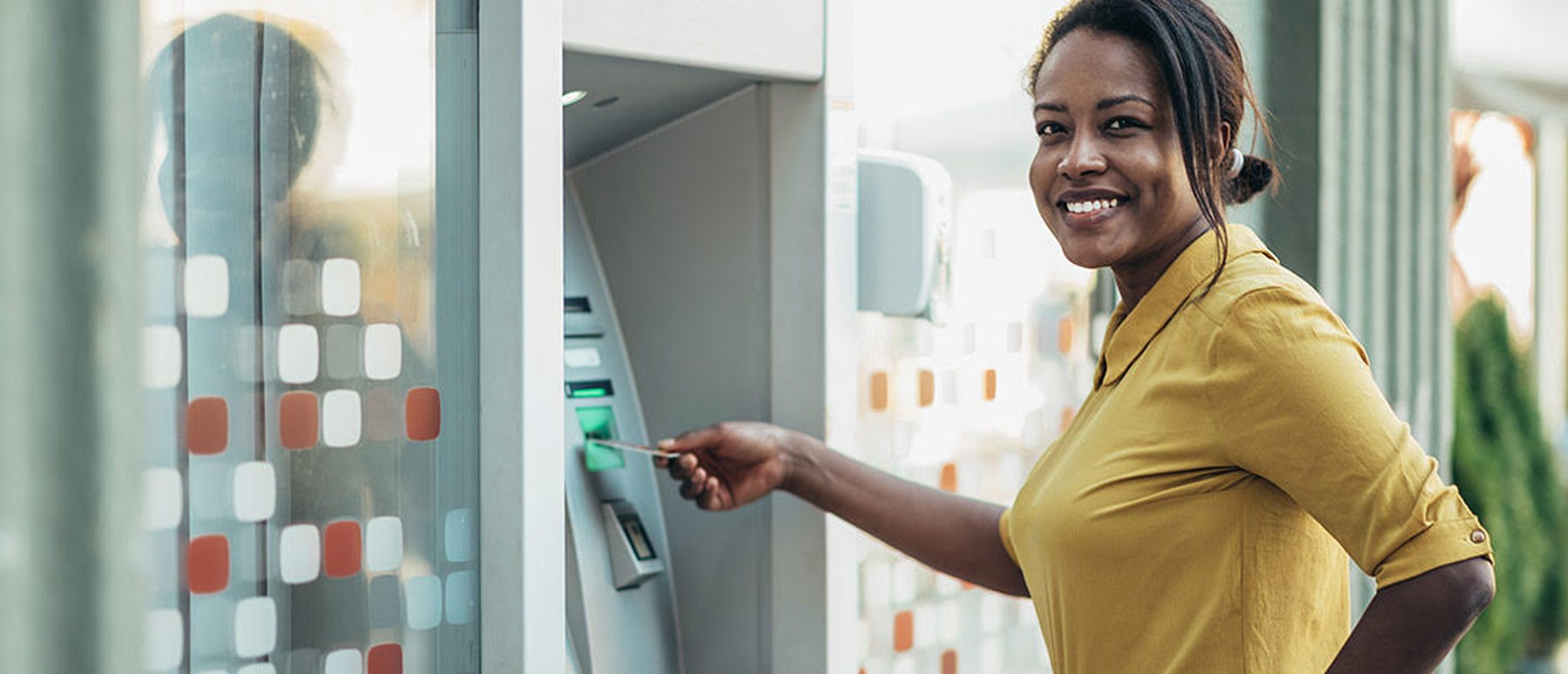 Een vrouw doet haar bankkaart in een pinautomaat