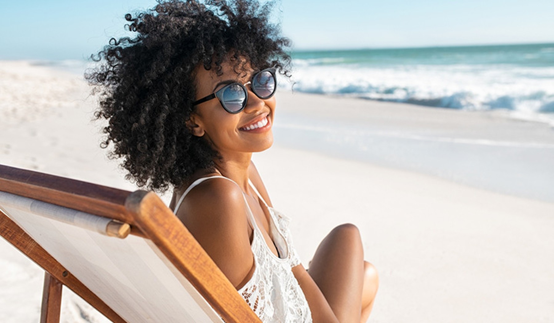 Vrouw met zonnebril op het strand