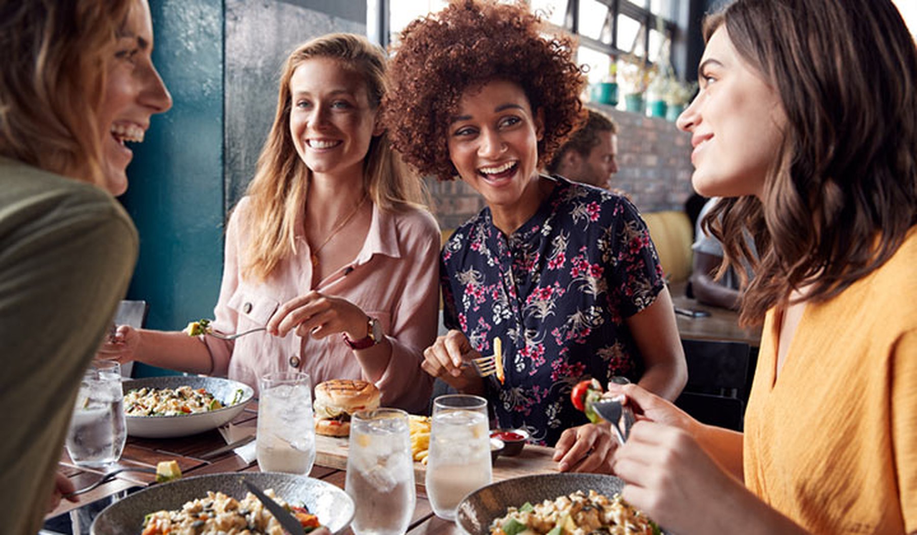 Vier vrouwen in restaurant met eten