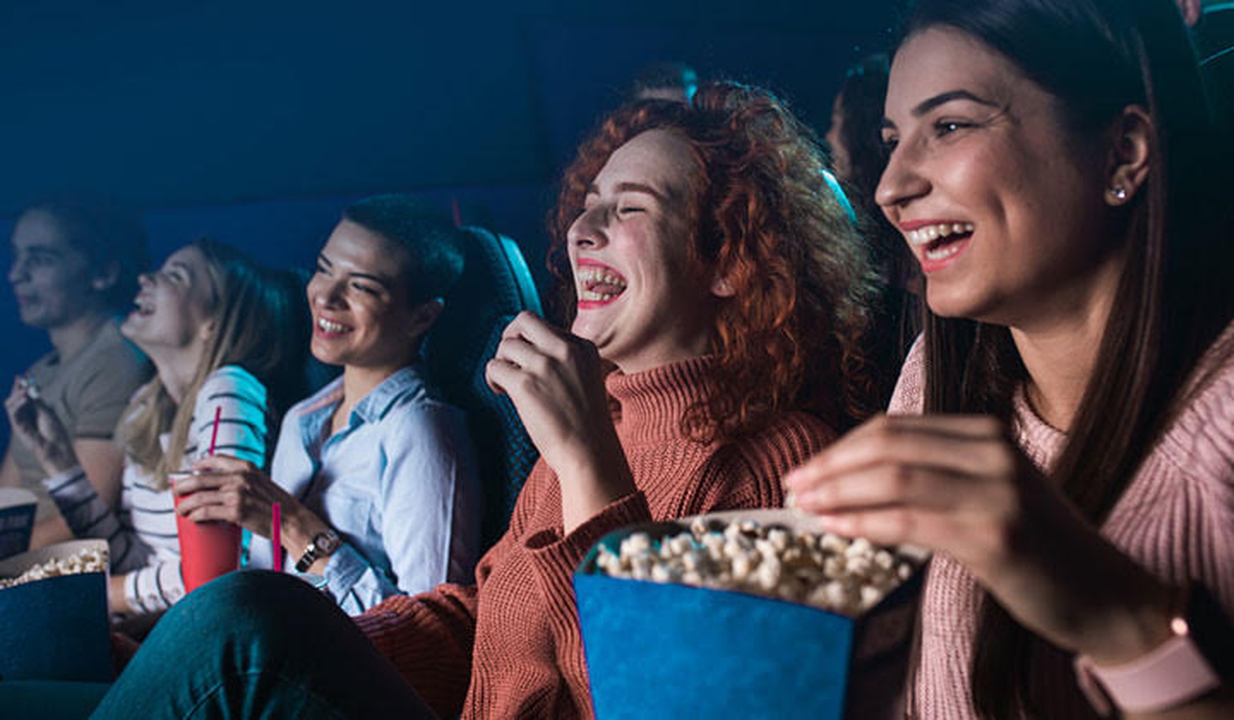 Lachend publiek in de bioscoop met popcorn