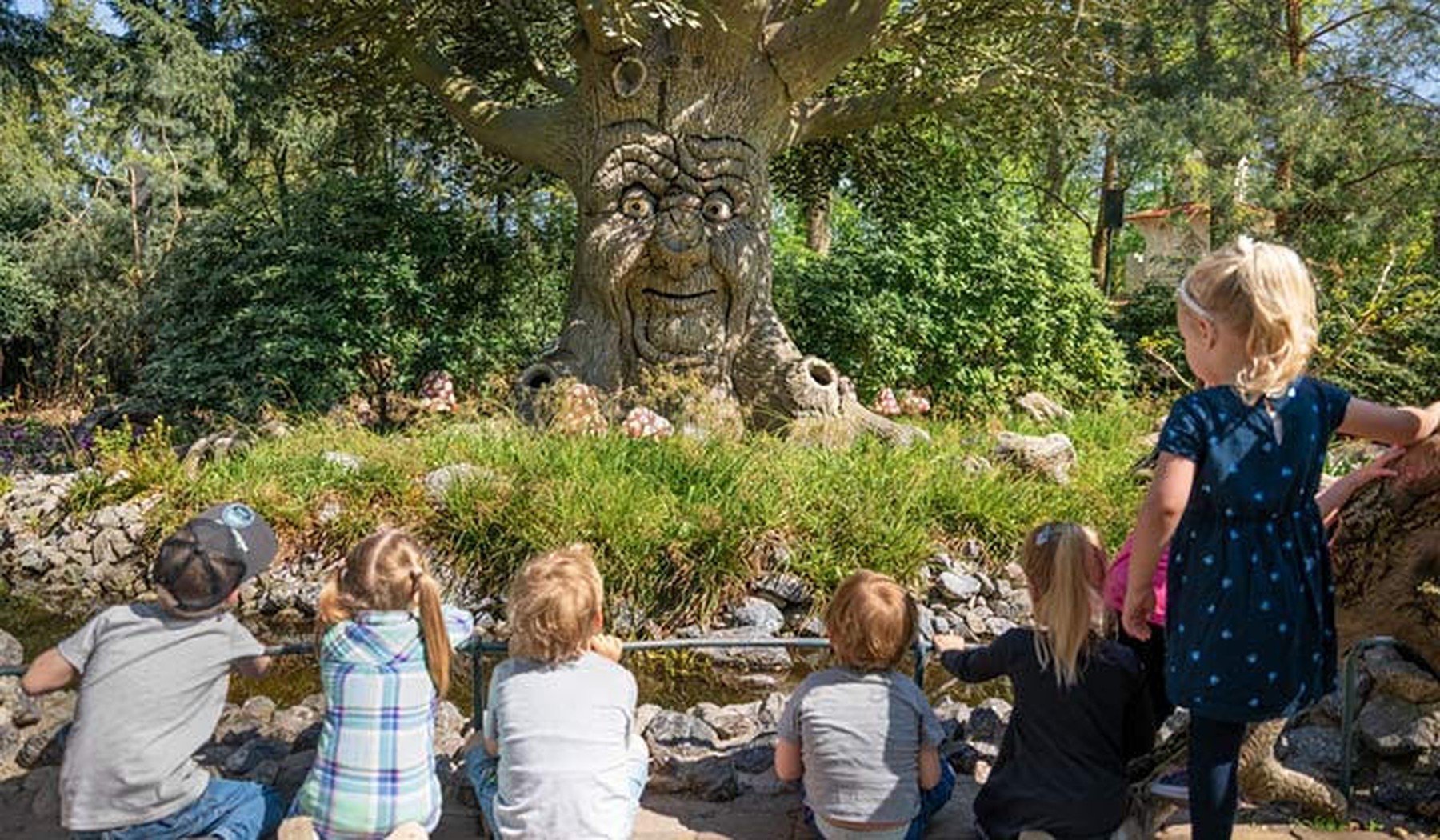 Kinderen zittend voor de Babbelboom in het Sprookjesbos van de Efteling